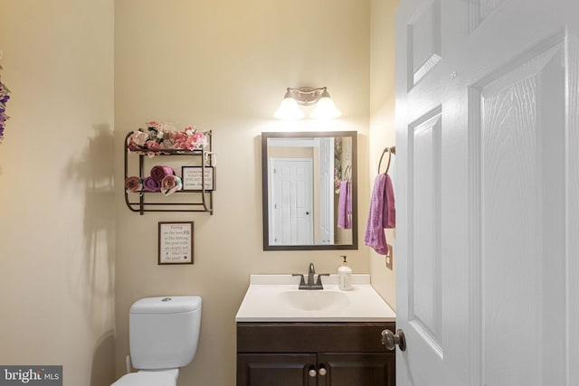 half bath featuring toilet and vanity