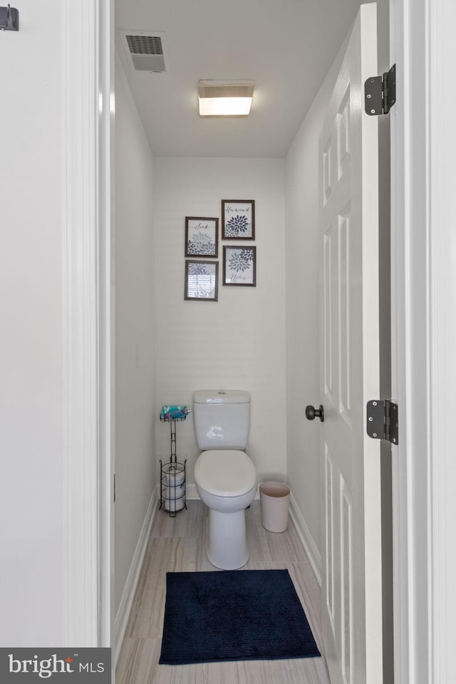 bathroom featuring baseboards, visible vents, and toilet