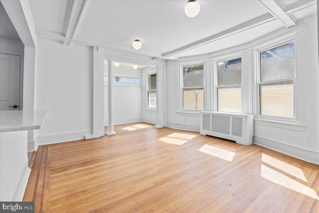 unfurnished sunroom with radiator and beam ceiling