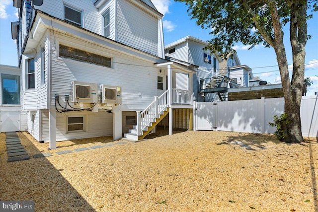 back of house featuring fence and stairway