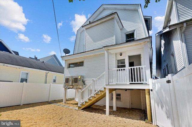 back of property with fence private yard and stairway