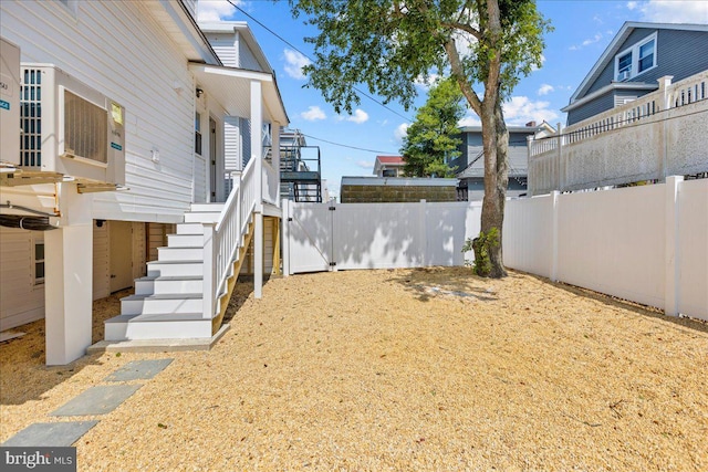 view of yard featuring a fenced backyard and stairs