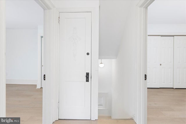 corridor featuring baseboards and wood finished floors