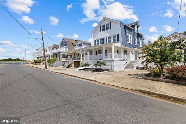 view of front of house featuring driveway, stairs, and a porch