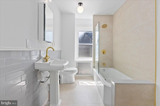 bathroom featuring tile patterned floors, tile walls, toilet, and shower / bathtub combination