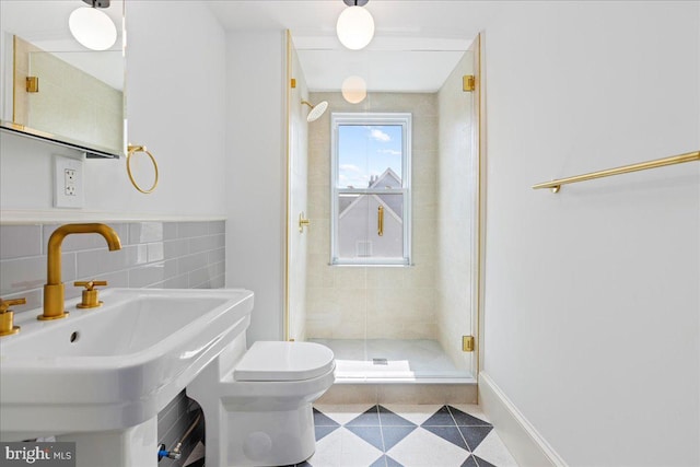 full bathroom with toilet, a sink, tile walls, a shower stall, and decorative backsplash