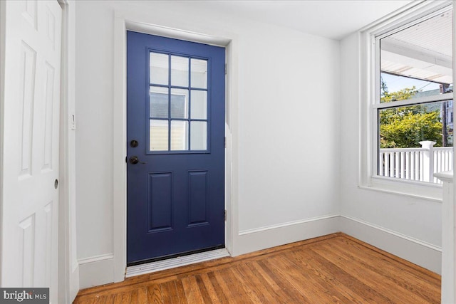 doorway with baseboards and wood finished floors