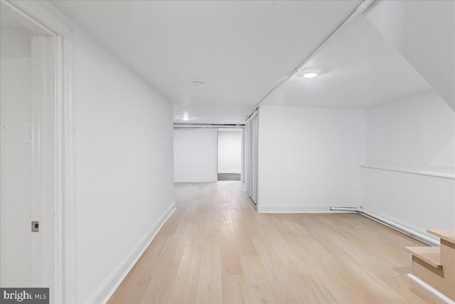 hall featuring wood finished floors and baseboards