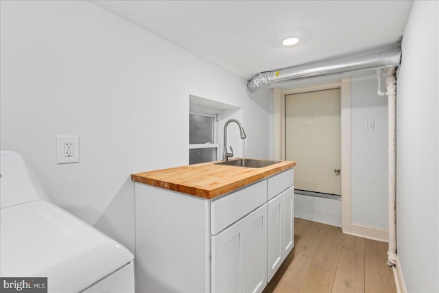 laundry room featuring laundry area, light wood-style flooring, and a sink