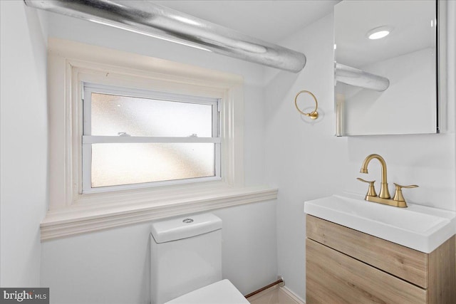 bathroom featuring a healthy amount of sunlight, vanity, and toilet