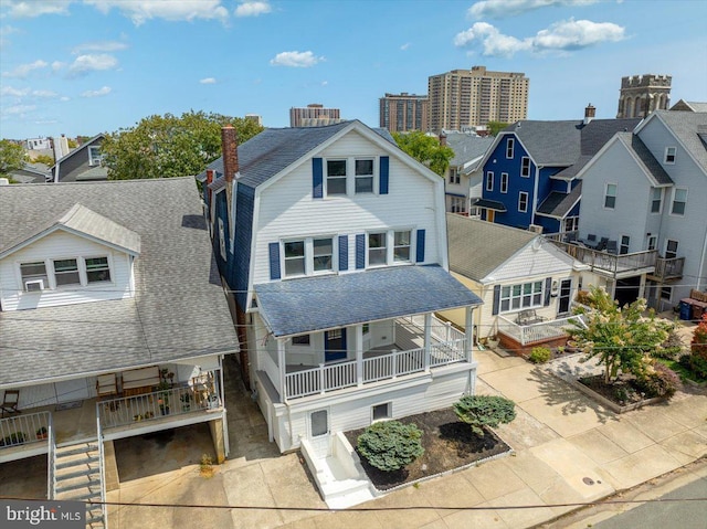 rear view of house featuring roof with shingles