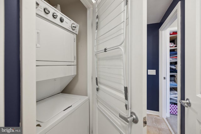 washroom featuring stacked washer / dryer and laundry area