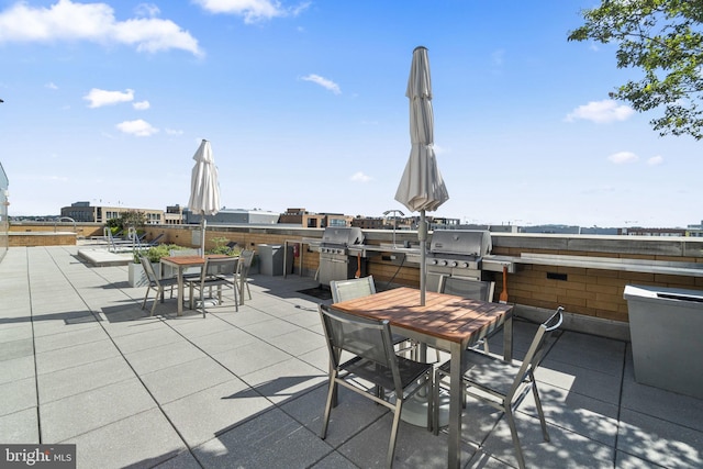 view of patio / terrace with exterior kitchen, outdoor dining area, and a grill