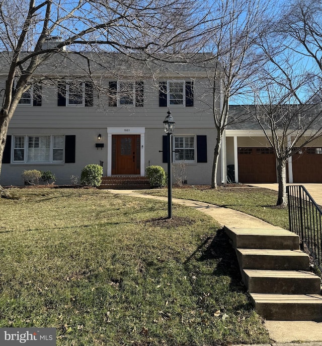 view of front of house with concrete driveway, a front lawn, and an attached garage