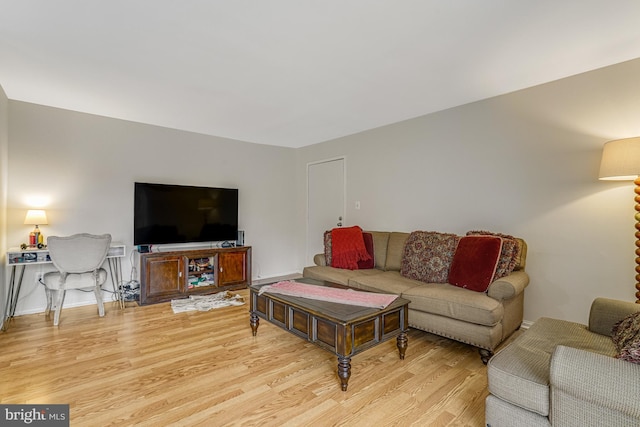 living area featuring baseboards and light wood-style floors