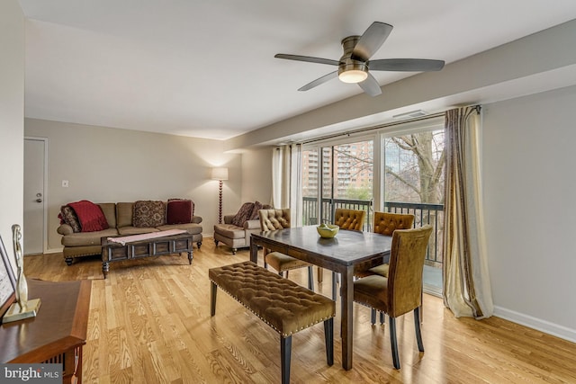 dining area with baseboards, ceiling fan, and light wood finished floors