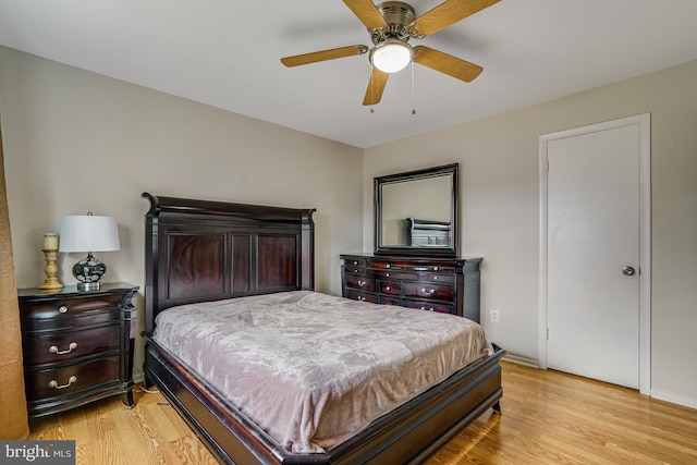 bedroom with light wood-type flooring, baseboards, and a ceiling fan