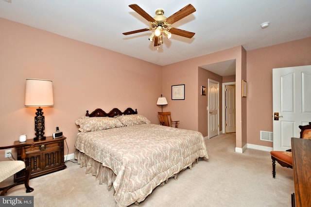 bedroom with baseboards, visible vents, a ceiling fan, and light colored carpet