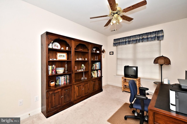 office area with a ceiling fan, light carpet, and baseboards