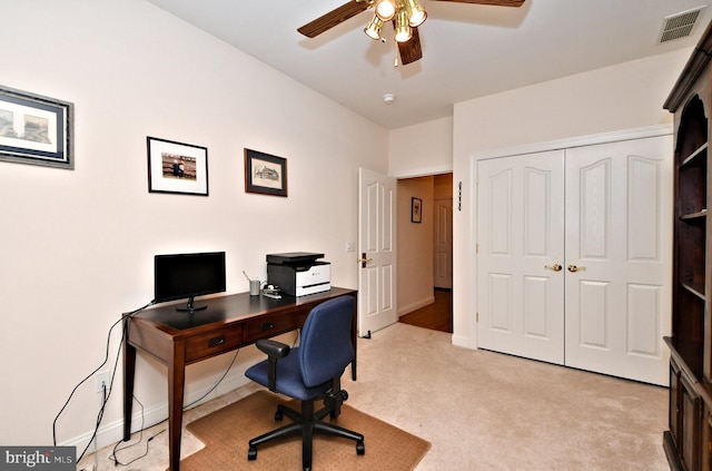 office with baseboards, visible vents, a ceiling fan, and light colored carpet