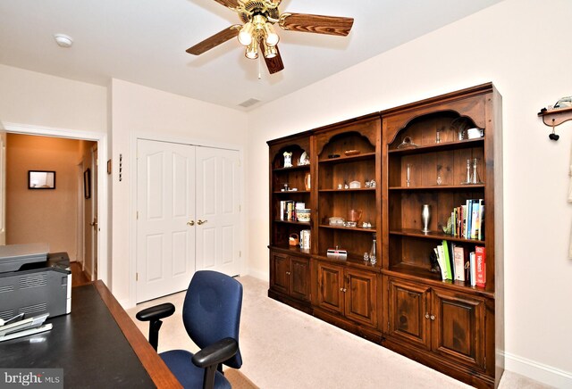 carpeted home office with a ceiling fan and baseboards