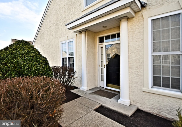 entrance to property featuring stucco siding