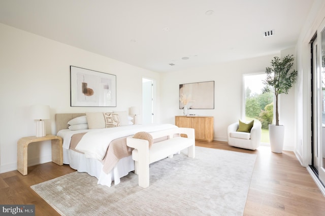 bedroom featuring light wood-type flooring, visible vents, and baseboards