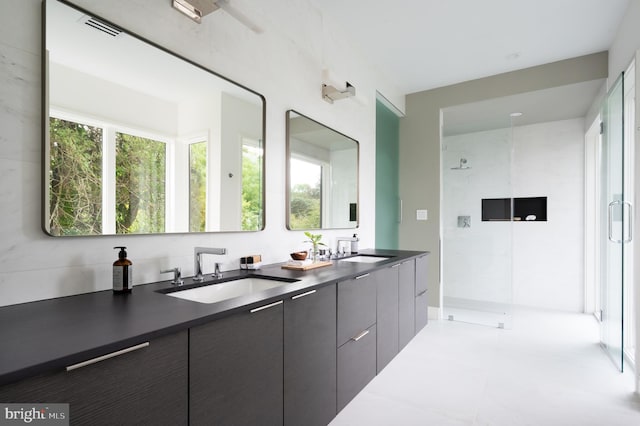 full bathroom with double vanity, walk in shower, and a sink