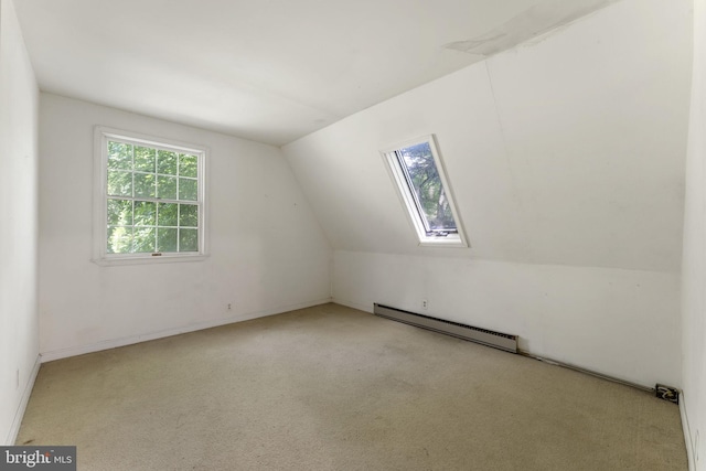 additional living space featuring lofted ceiling with skylight, a baseboard heating unit, and carpet flooring