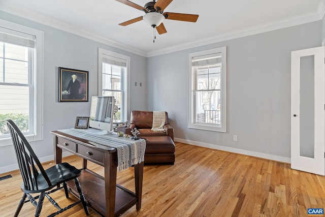 home office with light wood finished floors, visible vents, ornamental molding, a ceiling fan, and baseboards