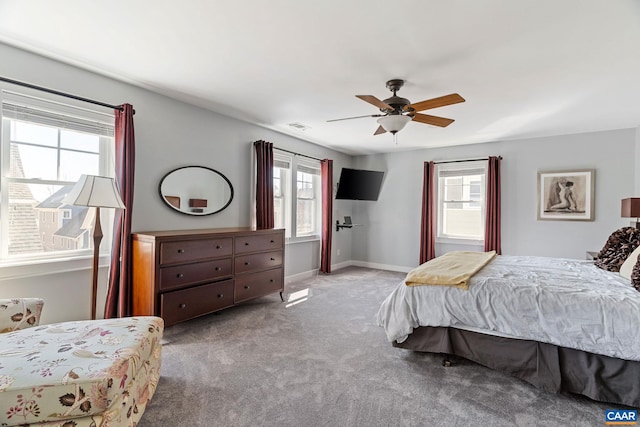 carpeted bedroom with ceiling fan, multiple windows, visible vents, and baseboards