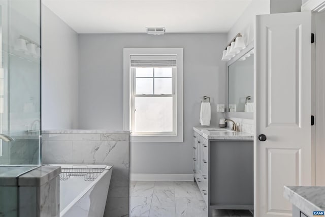 full bath with marble finish floor, visible vents, a soaking tub, and vanity