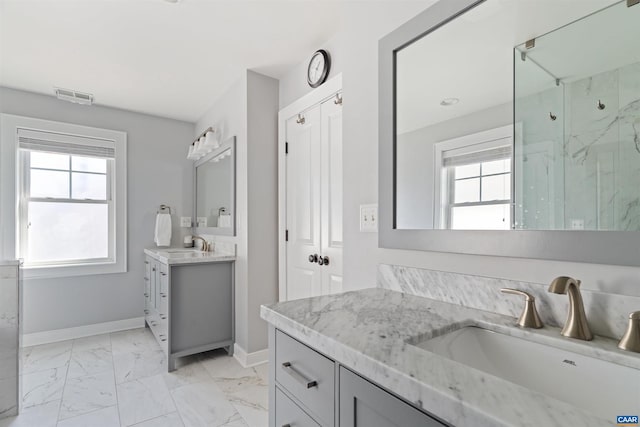 full bath featuring a sink, visible vents, baseboards, marble finish floor, and a marble finish shower