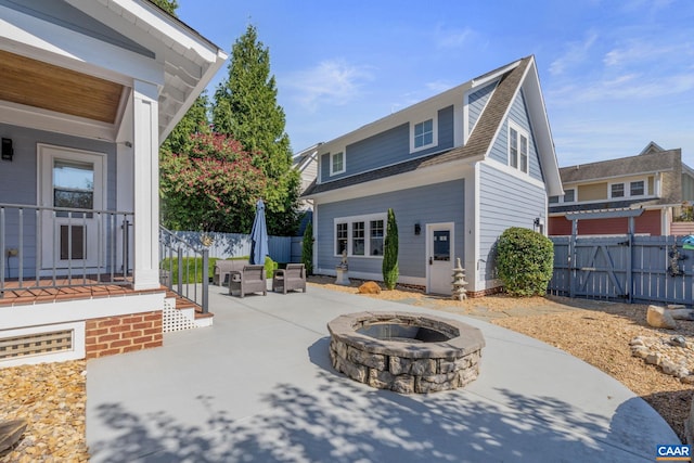 back of property featuring a patio area, an outdoor fire pit, and fence