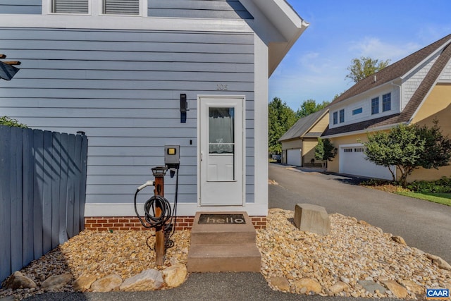 entrance to property featuring a garage and fence