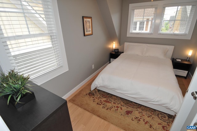 bedroom featuring baseboards and wood finished floors