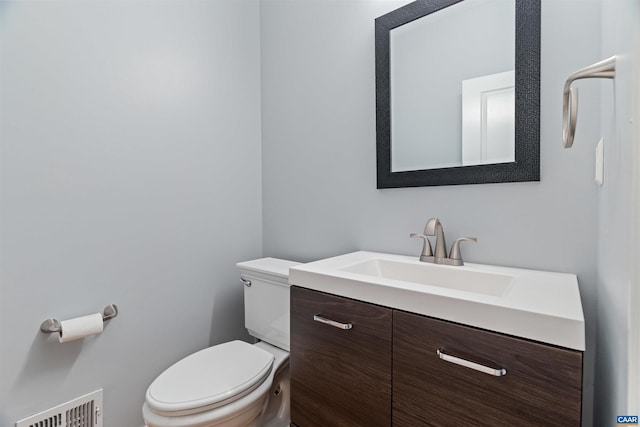 bathroom featuring visible vents, vanity, and toilet