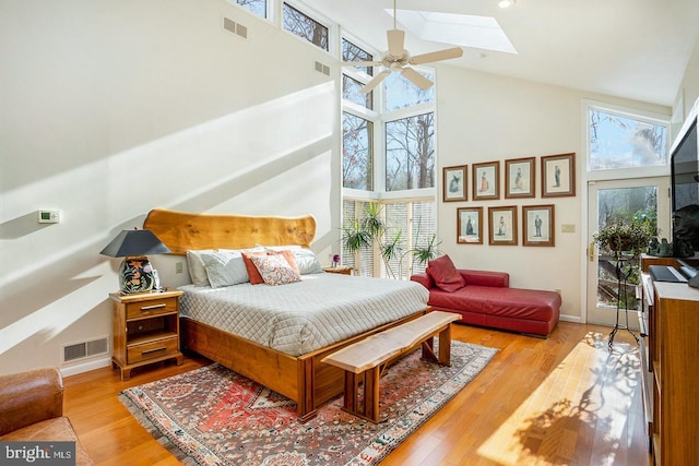 bedroom featuring light wood finished floors, multiple windows, a skylight, and visible vents