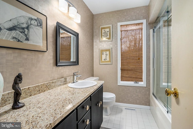 full bath featuring toilet, vanity, baseboards, combined bath / shower with glass door, and tile patterned floors