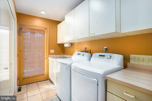 laundry room with light tile patterned floors, cabinet space, visible vents, a sink, and independent washer and dryer