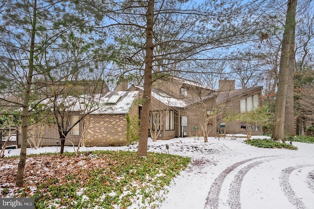 view of front of property with brick siding and a chimney