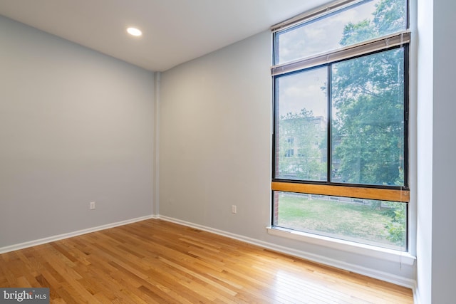 empty room with recessed lighting, light wood-type flooring, and baseboards