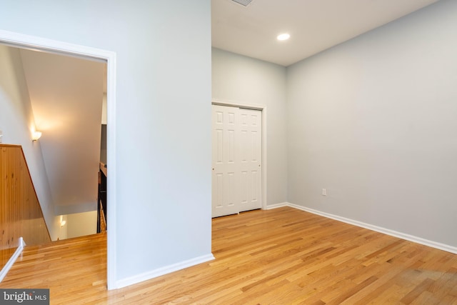 unfurnished bedroom featuring light wood finished floors, baseboards, a closet, and recessed lighting