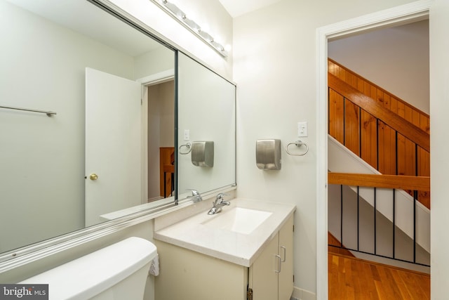 bathroom featuring vanity, toilet, and wood finished floors