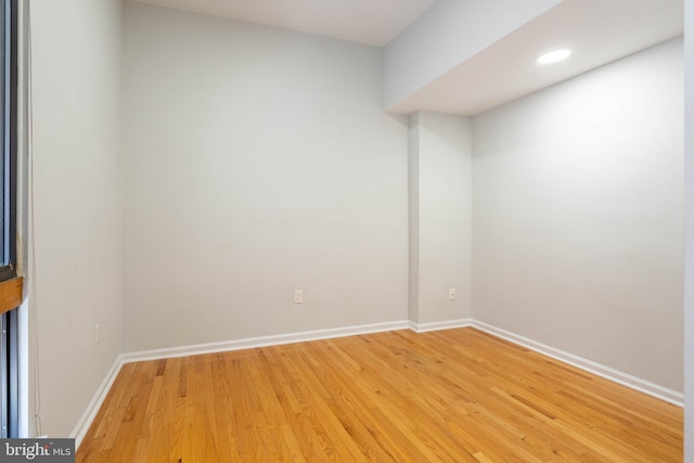 empty room with light wood finished floors, baseboards, and recessed lighting