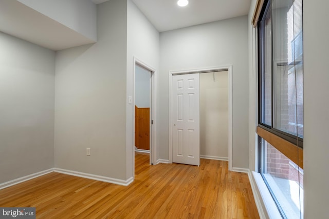 hall with a healthy amount of sunlight and light wood finished floors