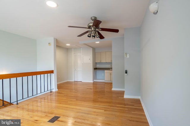 empty room featuring recessed lighting, baseboards, and light wood finished floors