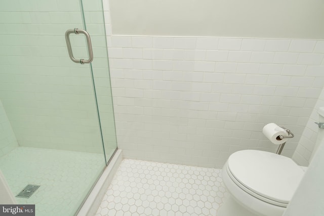 bathroom featuring a stall shower, tile patterned flooring, and toilet