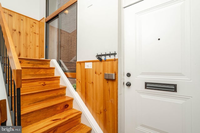 stairs featuring wood walls