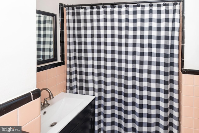 bathroom featuring vanity and tile walls